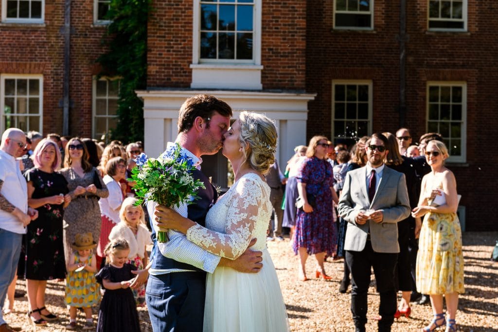 Beautiful kiss after their confetti run at their Mount Amelia boho wedding